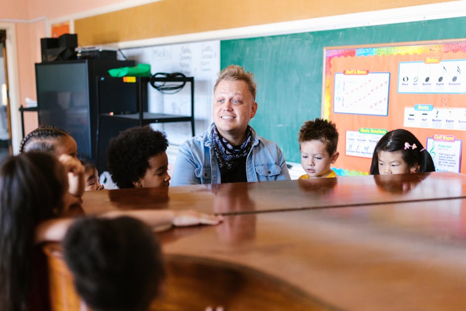 A teacher instructing young children in a music classroom, focused on piano learning